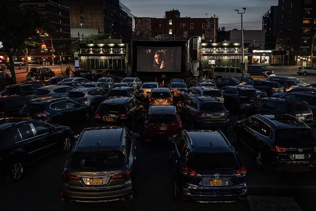 Patrons watch The Greatest Showman in Bel Aire diner parking lot, May 21, 2020. The Bel Aire diner in the Astoria neighborhood in Queens, New York City created a nightly open-air drive-in movie theater in the parking lot behind the restaurant. There is room for 45 socially distanced cars in the lot. Patrons pay $32 a vehicle to attend and can order diner food to their car. For every bag of popcorn sold, the diner feeds two first responders. Screenings, which are weather-dependent, are only scheduled about a week out, with new shows announced on the diner’s Instagram account and ticketing done through its website. The screening was a welcome, if surreal, reprieve for the New Yorkers who has been under strict quarantine since the start of the pandemic. (Photo by Timothy Fadek/Redux)