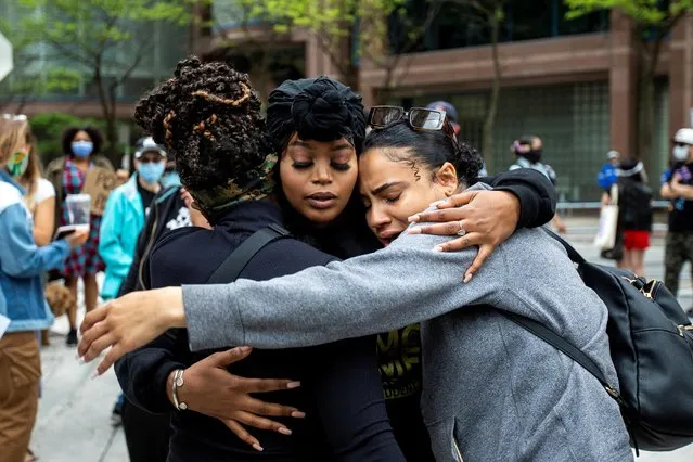 Patience Evbagharu hugs supporters outside Toronto Police headquarters as protesters march to highlight the deaths in the U.S. of Ahmaud Arbery, Breonna Taylor and George Floyd, and of Toronto's Regis Korchinski-Paquet, who died after falling from an apartment building while police officers were present, in Toronto, Ontario, Canada on May 30, 2020. (Photo by Carlos Osorio/Reuters)