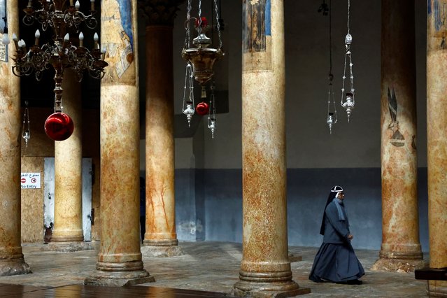 A nun walks through the Church of the Nativity, in Bethlehem, in the Israeli-occupied West Bank on December 25, 2023. (Photo by Clodagh Kilcoyne/Reuters)