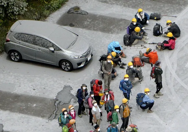 Climbers descended to a parking lot located halfway up Mt. Ontake rest after fleeing from the volcano eruption, in Kiso in Nagano Prefecture, central Japan, Saturday, September 27, 2014. (Photo by AP Photo/Kyodo News)