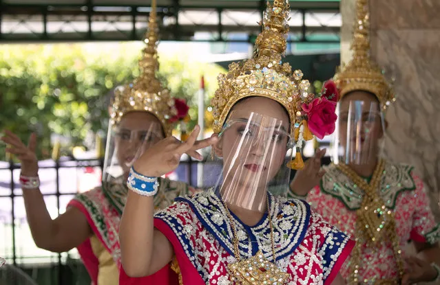 Thai classical dancers wearing face shield to help curb the spread of the coronavirus perform at the Erawan Shrine in Bangkok, Thailand, Thursday, May 28, 2020. Thai government continues to ease restrictions related to running business in capital Bangkok that were imposed weeks ago to combat the spread of COVID-19. (Photo by Sakchai Lalit/AP Photo)