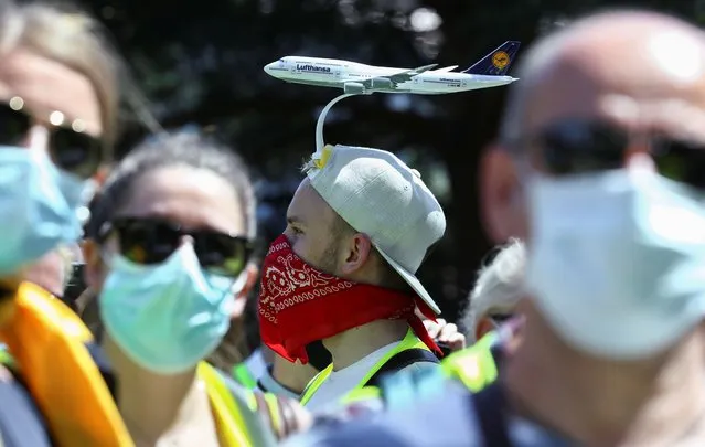 An employee of Lufthansa with a model plane attached to his head takes part in a protest against planned job cuts of Germany's flagship carrier due to the outbreak of the coronavirus disease (COVID-19), at the Lufthansa Aviation Centre in Frankfurt, Germany, June 24, 2020. (Photo by Ralph Orlowski/Reuters)