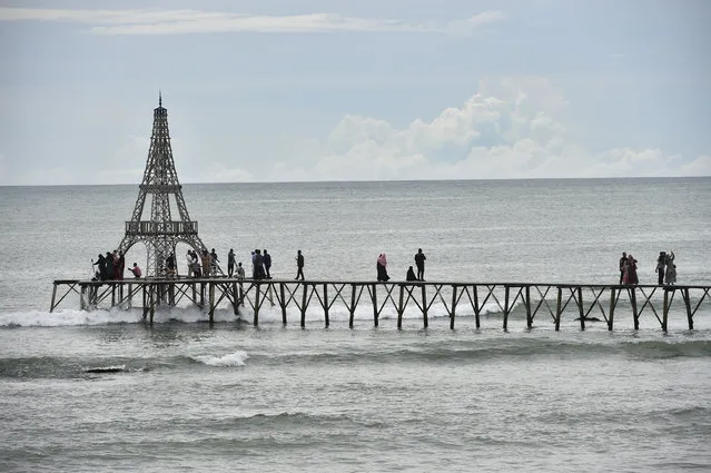 People walk on a pier on Lhokseudu beach, a local tourist attraction in Aceh province on June 7, 2020. (Photo by Chaideer Mahyuddin/AFP Photo)