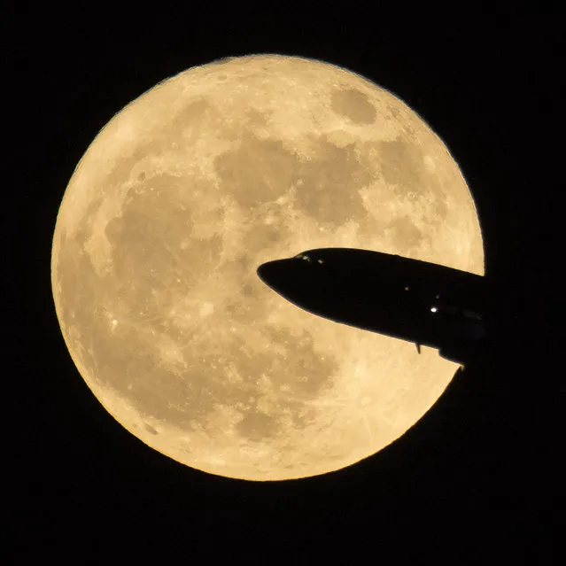 In this handout provided by NASA, an aircraft taking off from Ronald Reagan National Airport is seen passing in front of the moon as it rises on December 3, 2017 in Washington, DC. Today's full Moon is the first of three consecutive supermoons. The two will occur on Jan. 1 and Jan. 31, 2018. A supermoon occurs when the moon's orbit is closest (perigee) to Earth at the same time it is full. (Photo by NASA/Bill Ingalls via Getty Images)