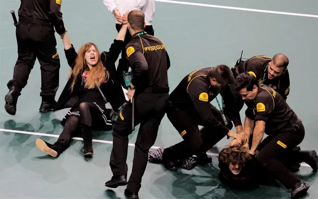 Climate change activists are detained by security after invading the court  during a Davis Cup quarter-final tennis match between Croatia and Spain in Malaga, Spain, Wednesday, November 23, 2022. (Photo by Jon Nazca/Reuters)