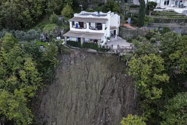 A house is left standing on the edge of a landslide in Casamicciola, on the southern Italian island of Ischia, in this picture taken Sunday, November 27, 2022. Exceptionally heavy rain caused a chunk of Mount Epomeo to come crashing down before dawn on Saturday, gaining speed as it entered the populated port town of Casamicciola, where it demolished buildings and carried cars and buses into the sea leaving at least eight people dead and more missing. Some 30 houses were inundated by the mud and water, and more than 200 residents in the town of 8,300 remain homeless, according to officials. (Photo by Salvatore Laporta/AP Photo)