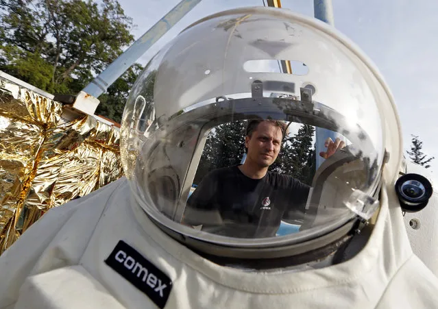 Comex Space division manager Peter Weiss checks the Gandolfi space suit before a training session in Marseille October 21, 2014. (Photo by Jean-Paul Pelissier/Reuters)