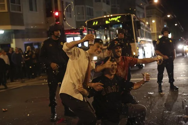 Fans celebrate in the street in the Mission District after the San Francisco Giants defeated the Kansas City Royals in Game 7 of the World Series, in San Francisco, California October 29, 2014. (Photo by Robert Galbraith/Reuters)