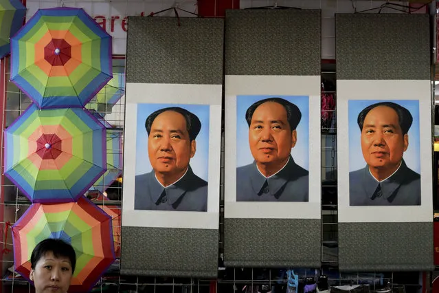 A salesperson sits near posters of the late communist leader Mao Zedong on display for sale at a shop near Tiananmen Square in Beijing, Friday, September 9, 2016. Friday marks the 40th anniversary of the death of Mao Zedong, who founded the People's Republic of China in 1949 and ran it virtually uncontested until his death on Sept. 9, 1976. (Photo by Andy Wong/AP Photo)