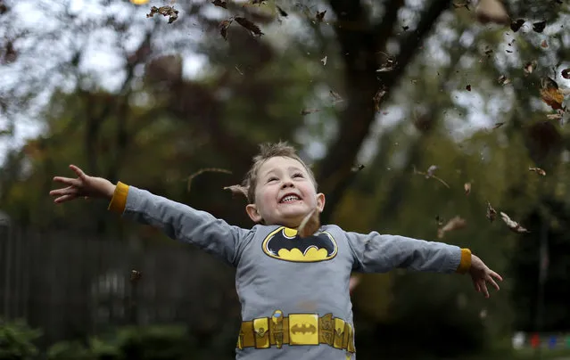 Benjamin Rocamp, who dressed as Batman, celebrates Halloween at the Flint family's annual Halloween block party in Silver Spring, Maryland October 31, 2014. The Flint family have decorated their house and thrown a theme block party for the last 17 years for neighborhood children and adults before the annual trick or treating. (Photo by Gary Cameron/Reuters)