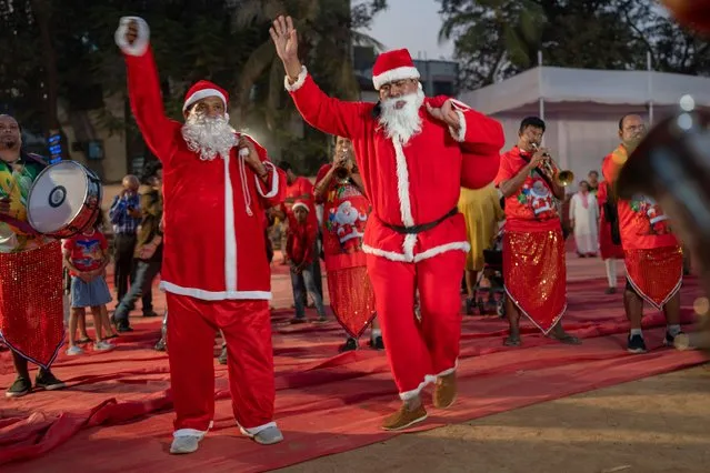 Men dressed as Santa Claus dance during a Christmas carnival in Mumbai, India, Thursday, December 22, 2022. (Photo by Rafiq Maqbool/AP Photo)