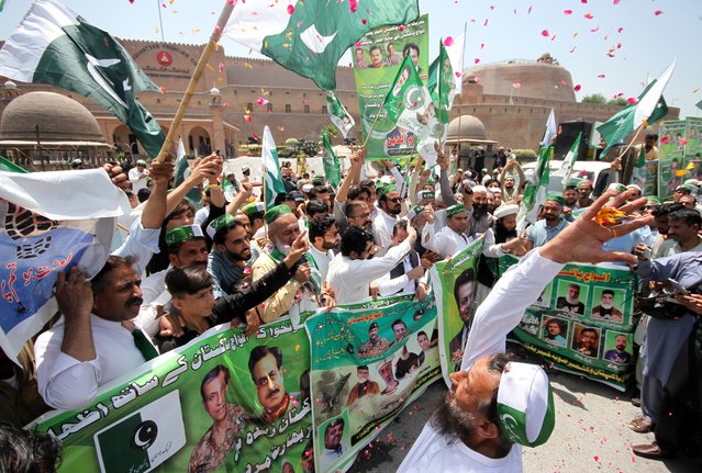 People hold national flags as they take part in a demonstration in front of the paramilitary FC headquarters to show their support for the Pakistan Army, a day after the ceasefire agreement between India and Pakistan was announced, in Peshawar, Pakistan, 11 May 2025. Pakistan and India have confirmed an immediate ceasefire, following days of military escalation between the two countries. The ceasefire, announced by US President Donald Trump and confirmed by both countries' officials, aims to halt military operations and focus on diplomatic solutions. (Photo by Arshad Arbab/EPA/EFE)