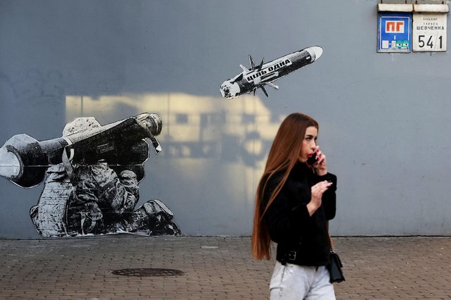 A woman walks by graffiti painted wall, as Russia’s attack on Ukraine continues, outside a coffee shop in Kyiv, Ukraine on December 4, 2022. (Photo by Shannon Stapleton/Reuters)