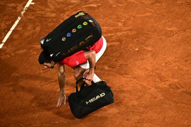 Serbia's Novak Djokovic touches the clay court as he leaves after losing his men's singles semi-final match against Italy's Jannik Sinner on day 13 of the French Open tennis tournament on Court Philippe-Chatrier at the Roland-Garros Complex in Paris on June 6, 2025. (Photo by Julien de Rosa/AFP Photo)