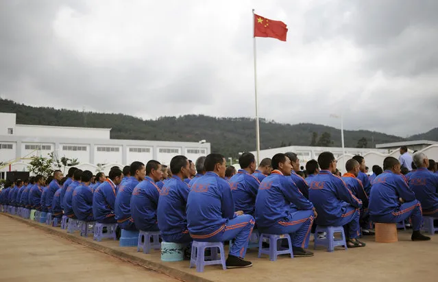 A Chinese national flag flies above male inmates as they watch a performance to mark the International Day against Drug Abuse and Illicit Trafficking at Kunming Municipal Compulsory Rehabilitation Centre in Yunnan province. (Photo by Wong Campion/Reuters)