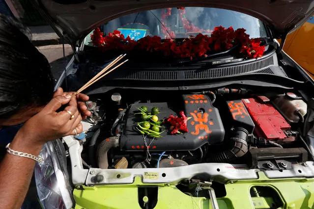 A taxi driver offers prayers to his car during the Vishwakarma Puja festival in Kolkata, India, September 17, 2016. (Photo by Rupak De Chowdhuri/Reuters)