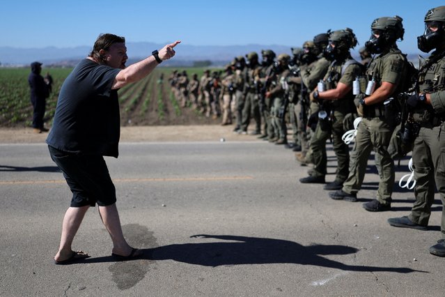 A protester gestures as U.S. federal agents block a road leading to an agricultural facility where U.S. federal agents and immigration officers carried out an operation, in Camarillo, California, on July 10, 2025. (Photo by Daniel Cole/Reuters)