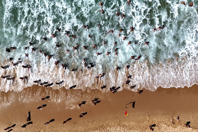 This aerial photograph shows beach-goers gathering on a beach alongside the Atlantic Ocean in Carcans, south-western France on July 22, 2025. (Photo by Christophe Archambault/AFP Photo)