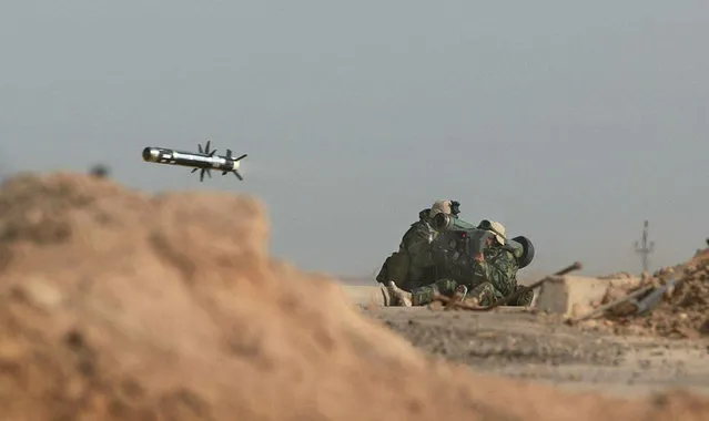 U.S. Marines from the 15 Marine Expeditionary Unit fire a shoulder-launched Javelin missile during a battle with Iraqi troops at the port in Umm Qasr, Iraq, on March 23, 2003. (Photo by Simon Walker/AP Photo/The London Times/The Atlantic)