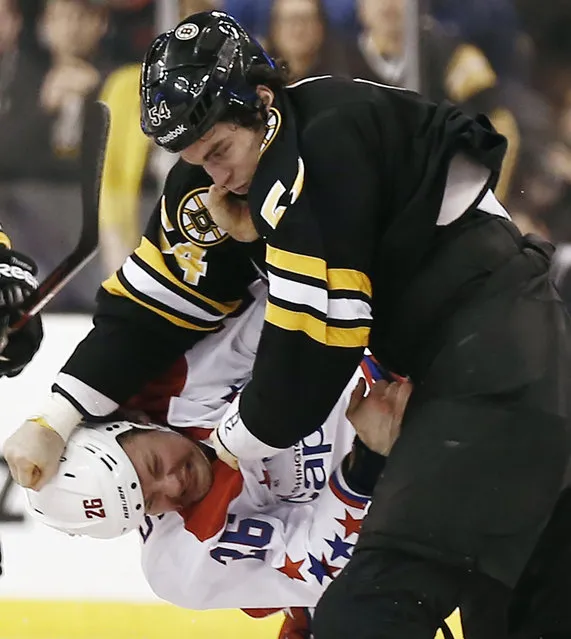 Boston Bruins' Adam McQuaid, top, fights with Washington Capitals' Matt Hendricks (26) during the third period of Boston's 4–1 win in an NHL hockey game in Boston, Saturday, March 16, 2013. (Photo by Winslow Townson/AP Photo)