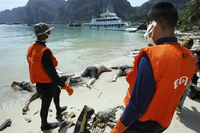 Rescue workers stand near dead bodies washed ashore in Ton Sai Bay in Thailand's Phi Phi island in this December 28, 2004 file photo. (Photo by Luis Enrique Ascui/Reuters)