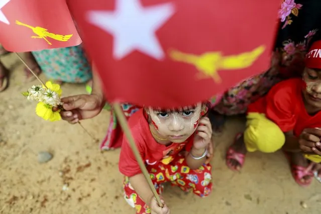Children wait for Myanmar pro-democracy leader Aung San Suu Kyi's arrival during her campaign rally for the upcoming general election in her constituency Kawhmu township, Yangon division October 24, 2015. (Photo by Soe Zeya Tun/Reuters)