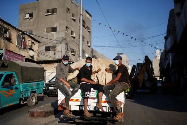 Palestinians wearing protective face masks ride on a truck amid the coronavirus disease (COVID-19) outbreak, in the northern Gaza Strip on September 22, 2020. (Photo by Suhaib Salem/Reuters)