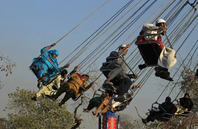 People ride a swing at the Lake View park in Islamabad December 4, 2014. (Photo by Faisal Mahmood/Reuters)