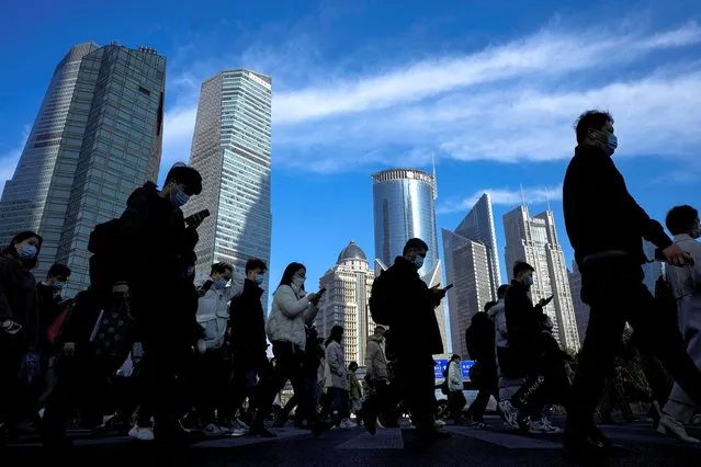 People cross a street near office towers in the Lujiazui financial district, ahead of the National People's Congress (NPC), in Shanghai, China on February 28, 2023. (Photo by Aly Song/Reuters)