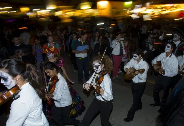 Participants play violins as they march during a candlelight procession at the end of a three-day "Day of The Dead" (Dia de los Muertos) celebration, which saw hundreds walk to El Campo Santo cemetery, in Old Town San Diego, California, November 2, 2015. (Photo by Mike Blake/Reuters)