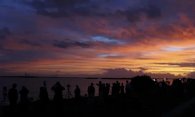 News photographers and journalists watch as the sun rises on the Delta IV Heavy rocket carrying the Orion spacecraft waiting for liftoff  on the launch pad from the Cape Canveral Air Force Station in Cape Canaveral, Florida December 4, 2014. (Photo by Scott Audette/Reuters)