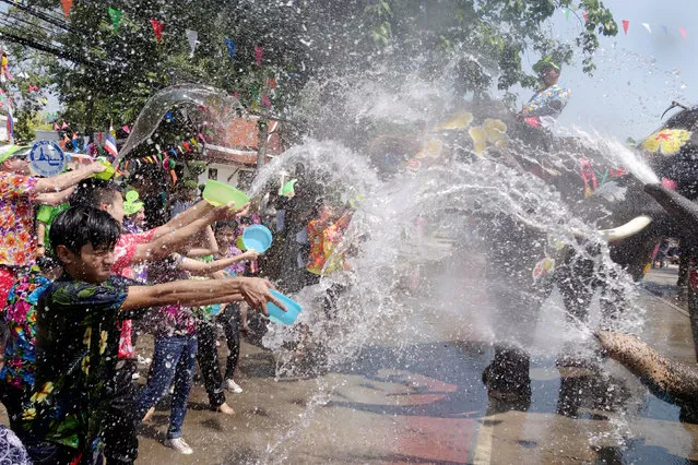 Elephants and people play with water during the celebration of Songkran Water Festival, to commemorate Thailand's New Year in Ayutthaya, Thailand April 11, 2018. (Photo by Jorge Silva/Reuters)