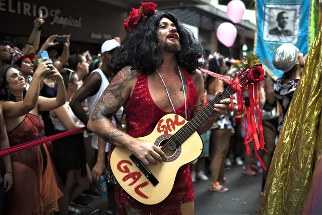 Leandro Vieira, carnival director of the Imperatriz Leopoldinense samba school, plays the guitar and wears a costume in honor of late Brazilian singer Gal Costa, during the pre-carnival parade by the Cordao do Boitata block in Rio de Janeiro, Brazil, Sunday, February 12, 2023. Vieira's job includes helping pick the samba school's theme for the year, calling shots on the material for costumes and often choosing who will feature on the top of majestic floats. (Photo by Bruna Prado/AP Photo)