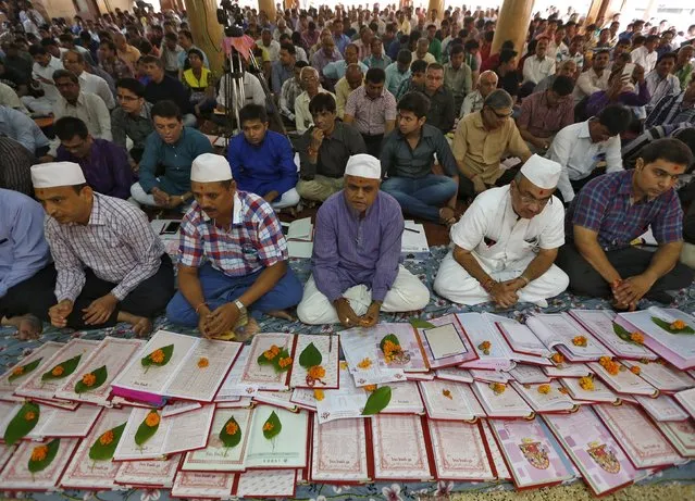 Indian businessmen sit beside their record-keeping books as part of a ritual to worship the Hindu deity of wealth goddess Lakshmi on Diwali, the festival of lights, in Ahmedabad, India, November 11, 2015. The ritual known also as "Muhurat trading" is considered auspicious by traders and marks the beginning of the new trading year for the Gujarati community in India, who form the bulk of share brokers and businessmen in India. (Photo by Amit Dave/Reuters)