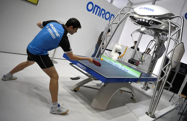 German table tennis player Dimitrij Ovtcharov plays against table tennis robot “Forpheus” at the world's biggest industrial fair, “Hannover Fair”, in Hanover, Germany, April 22, 2018. (Photo by Fabian Bimmer/Reuters)