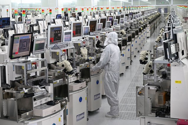 A technician works on chip processing equipment at a semiconductor manufacturing plant in Suqian, in eastern China's Jiangsu province on October 20, 2025. (Photo by AFP Photo/China Stringer Network)