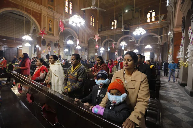 Indian Christians, some wearing face masks as a precaution against the coronavirus, attend a Christmas mass at St. Joseph's Cathedral in Prayagraj, India. Friday, December 25, 2020. (Photo by Rajesh Kumar Singh/AP Photo)