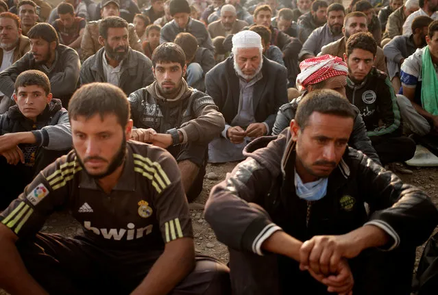 Newly displaced men sit at a check point in Qayyara, east of Mosul, Iraq October 26, 2016. (Photo by Goran Tomasevic/Reuters)