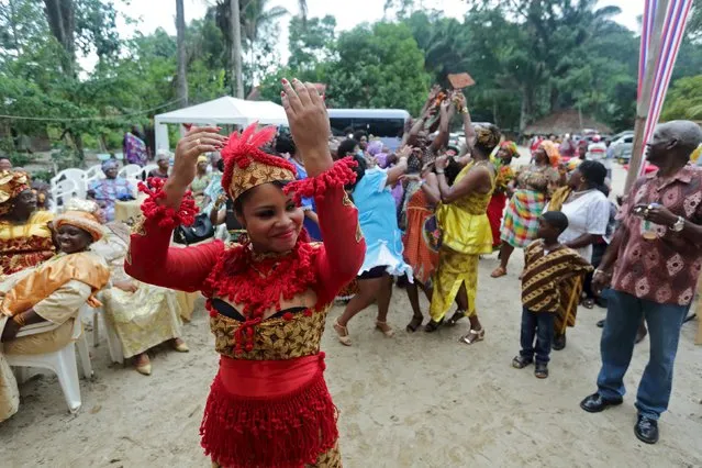 Surinamese bride Melissa Karwafodi throws a traditional cloth to her female guests after she was wedded in the first Winti marriage ever to be held in public, in district Para, Suriname, November 16, 2015. (Photo by Ranu Abhelakh/Reuters)