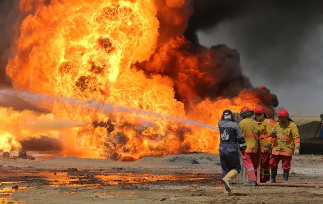 Iraqi firefighters try to stop the fire of burning oil wells in Kirkuk, northern Iraq, 02 June 2016. Two Khabbaz oil field wells in Kirkuk Province, northern Iraq, exploded by suspected insurgents, a security official said. (Photo by EPA/Stringer)