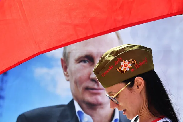 A pro Putin protester demonstrates in front of the Presidential palace in the Vienna Hofburg, Austria, on June 5, 2018 prior Russian President's visit to Austrian counterpart. Putin meets Austrian President Alexander Van der Bellen as well as Austrian Chancellor Sebastian Kurz on June 05, 2018. The FPOe – the junior partner to Kurz's People's Party – supports Russia's claim of sovereignty over Crimea and advocates the easing of economic sanctions levied against Moscow over its role in the Ukrainian crisis. (Photo by Joe Klamar/AFP Photo)