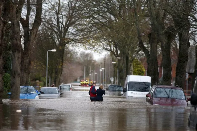 Residents wade through flood waters in the Warwick Road area of Carlisle, Britain December 6, 2015. British police have declared a major incident in northern England after prolonged heavy rain caused widespread flooding and forced emergency services to evacuate residents from their homes. (Photo by Phil Noble/Reuters)