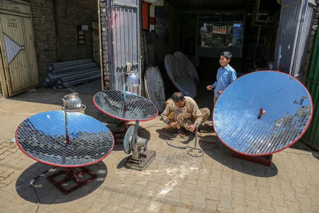 Ghulam Abbas (L), a blacksmith who manufactures Solar Cooker at his workshop in Kabul, Afghanistan, 08 May 2023. (Photo by Samiullah Popal/EPA/EFE)