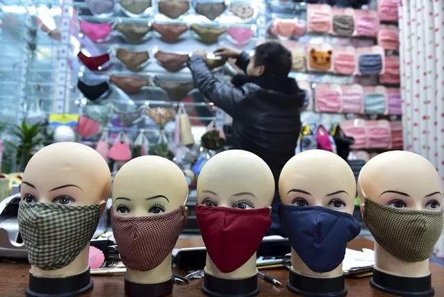 A vendor arranges a shelf full of masks as he waits for customers in a shopping mall in Yiwu, Zhejiang province, China, December 7, 2015. Picture taken December 7, 2015. (Photo by Reuters/China Daily)