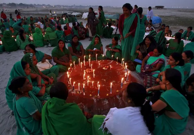 Women sit around candles after lighting them to celebrate Dev Deepawali festival on the banks of the Ganges River in Allahabad, India, November 25, 2015. Dev Deepawali is celebrated on the fifteenth day of Diwali, the Hindu festival of lights, on the full moon day in the month of Karthik (also known as Karthik Purnima). (Photo by Jitendra Prakash/Reuters)