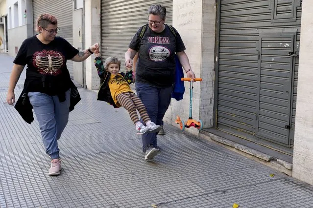 Anastasia Domini, left, and her wife Anna, swing their daughter Una as they walk to a park in Buenos Aires, Argentina, Saturday, April 22, 2023. The same-sеx couple are part of an increasing number of Russians from the LGBTQ+ community who left their homeland to escape discrimination and settled in Argentina, where same-s*x marriage has been legal for more than a decade. (Photo by Natacha Pisarenko/AP Photo)