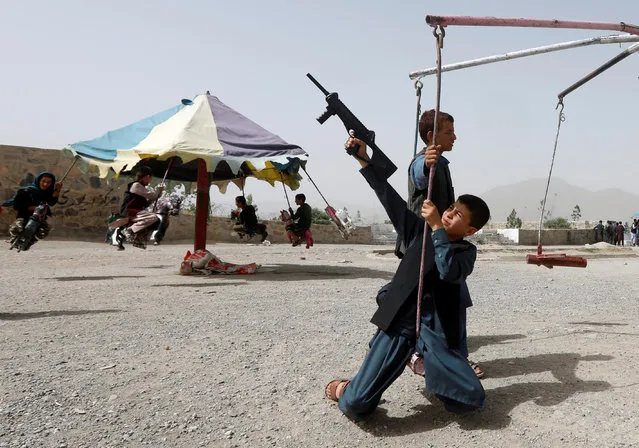 Afghan children ride the swing ride during the first day of the Muslim holiday of Eid al-Fitr in Kabul, Afghanistan June 15, 2018. (Photo by Omar Sobhani/Reuters)