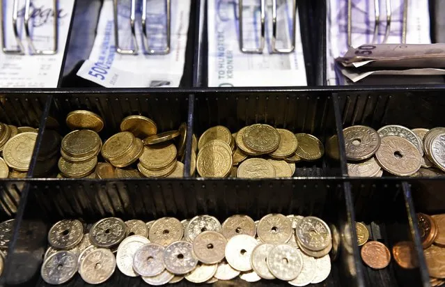 Coins in a cash-box of Danish crowns are pictured in a pub in Copenhagen, January 22, 2015. The Danish central bank cut its key policy rate on Thursday for the second time this week to defend the crown's peg to the euro after the European Central Bank unveiled a stimulus package that weakened the single currency. (Photo by Fabian Bimmer/Reuters)