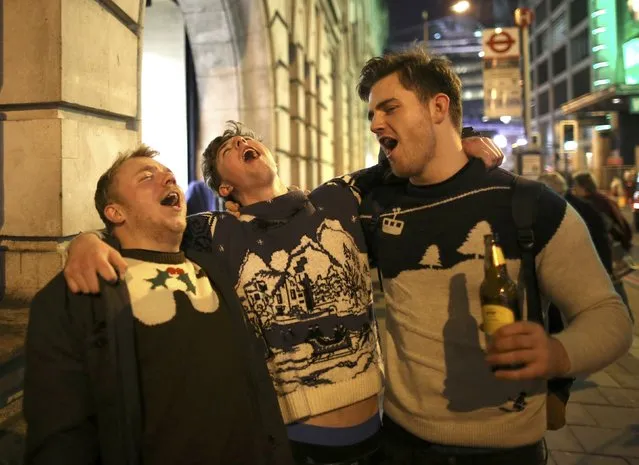 Young men sing outside Victoria station in London during the Christmas party season, December 17, 2015. (Photo by Paul Hackett/Reuters)