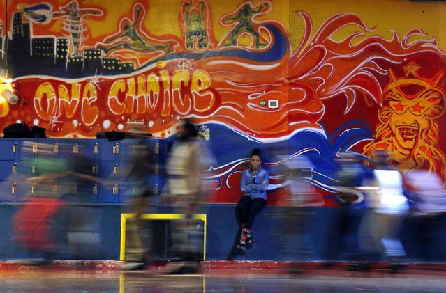 A woman sits along a wall as others roller skate past at Rich City Skate in Richton Park, Illinois, January 12, 2015. (Photo by Jim Young/Reuters)